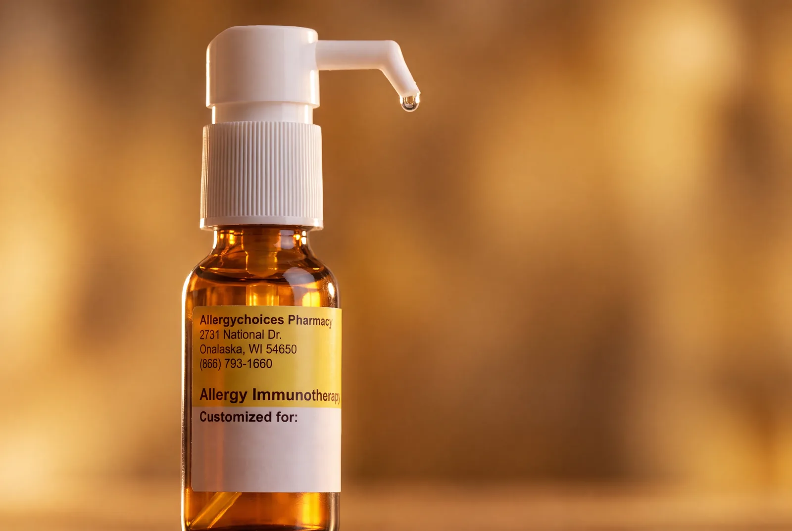 A single drop suspended from a glass allergy dropper